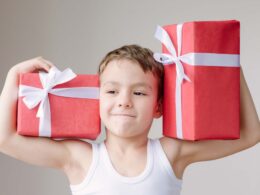 chłopiec trzymający prezenty z okazji Dnia Dziecka