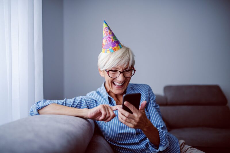 odbieranie cyfrowej kartki urodzinowej na telefonie przez kobietę
